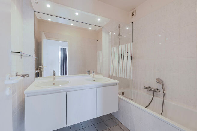 Dit prachtige appartement met 2 slaapkamers met staanplaats en kelder, bevindt zich op de 6e verdieping van een goed onderhouden mede-eigendom, omgeven door groen en gunstig gelegen nabij het UZ Jette.

INDELING:
Bij binnenkomst stap je in een centrale in