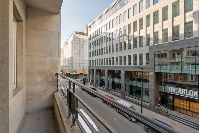 This classy one-bedroom apartment with 2 terraces and 2 spacious attic storerooms is located on the 2nd floor of a co-ownership building, perfectly situated in the European Quarter, between Schuman and Brussels Park.

The apartment is arranged as follows: