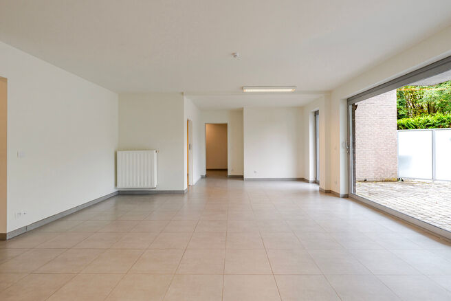 This ground-floor apartment with two bedrooms is located in a peaceful, rural setting close to the Flemish border, within a well-maintained co-ownership.
Although it does not yet have a kitchen or bathroom, the property offers great potential. With all co