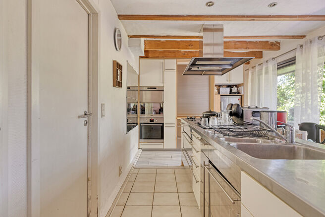 This 3-bedroom family home with garage and garden is located on a 594 m² plot in a pleasant and quiet residential area, at an excellent location near the renowned Kruikenburg Castle and Park.

LAYOUT:
The ground floor features a central entrance hall wit
