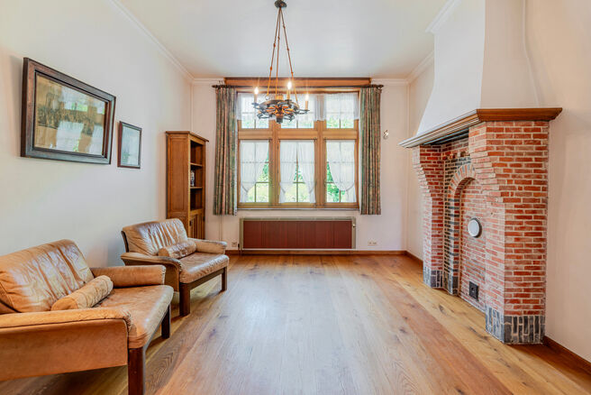 Deze karaktervolle burgerwoning in Vlaamse neotraditionele stijl, met haar statige trapgevel en authentieke elementen, ligt op een royaal perceel van 860 m² in het landelijke Beigem (Grimbergen).

Op het gelijkvloers bevindt zich de inkomhal die toegang 