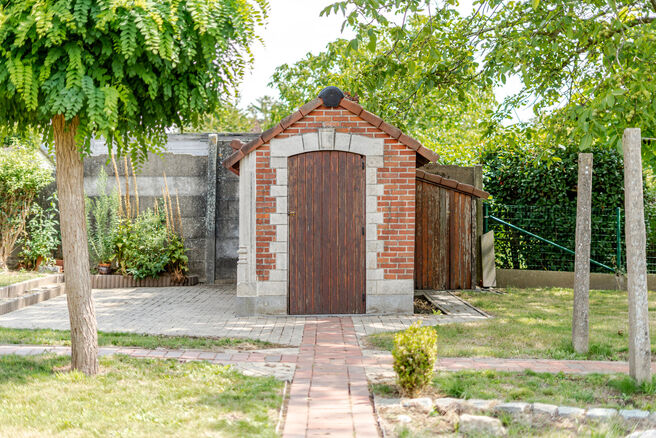 Deze karaktervolle burgerwoning in Vlaamse neotraditionele stijl, met haar statige trapgevel en authentieke elementen, ligt op een royaal perceel van 860 m² in het landelijke Beigem (Grimbergen).

Op het gelijkvloers bevindt zich de inkomhal die toegang 