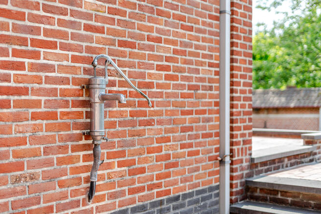 Deze karaktervolle burgerwoning in Vlaamse neotraditionele stijl, met haar statige trapgevel en authentieke elementen, ligt op een royaal perceel van 860 m² in het landelijke Beigem (Grimbergen).

Op het gelijkvloers bevindt zich de inkomhal die toegang 