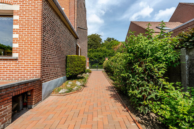 Deze karaktervolle burgerwoning in Vlaamse neotraditionele stijl, met haar statige trapgevel en authentieke elementen, ligt op een royaal perceel van 860 m² in het landelijke Beigem (Grimbergen).

Op het gelijkvloers bevindt zich de inkomhal die toegang 