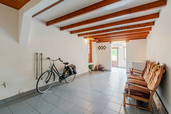 Deze karaktervolle burgerwoning in Vlaamse neotraditionele stijl, met haar statige trapgevel en authentieke elementen, ligt op een royaal perceel van 860 m² in het landelijke Beigem (Grimbergen).

Op het gelijkvloers bevindt zich de inkomhal die toegang 