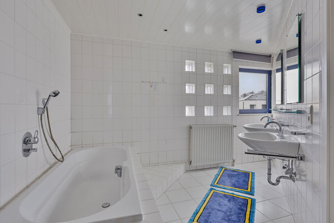 Deze ruime gezinswoning met drie slaapkamers, een praktische en ruime garage en een prachtig aangelegde tuin is uitstekend gelegen in een rustige, landelijke omgeving.

Indeling van de woning:

Bij binnenkomst betreedt u de inkomhal met een apart toilet e