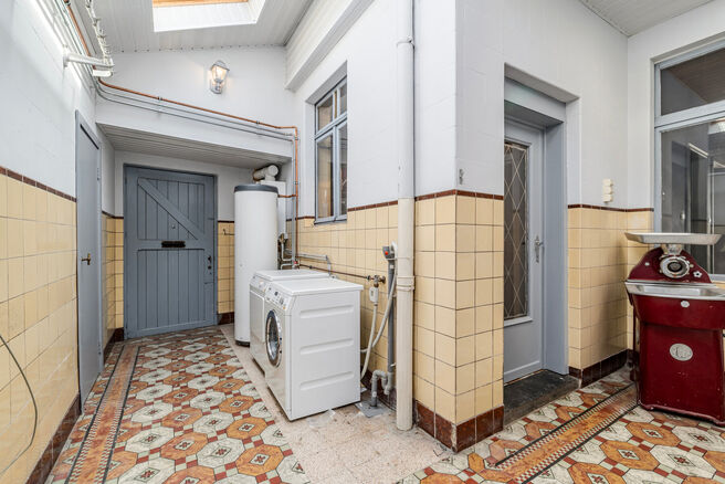 Deze hoekwoning met 3 slaapkamers en garage is centraal gelegen, op wandelafstand van de dorpskern van Machelen.

INDELING:
Op het gelijkvloers bevindt zich de voormalige slagerswinkel. Verder vindt u een ruime eetkamer of bureau aan de voorzijde, een woo
