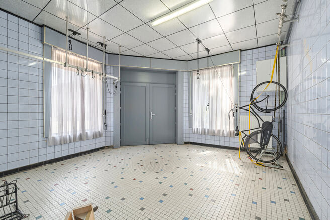 Deze hoekwoning met 3 slaapkamers en garage is centraal gelegen, op wandelafstand van de dorpskern van Machelen.

INDELING:
Op het gelijkvloers bevindt zich de voormalige slagerswinkel. Verder vindt u een ruime eetkamer of bureau aan de voorzijde, een woo