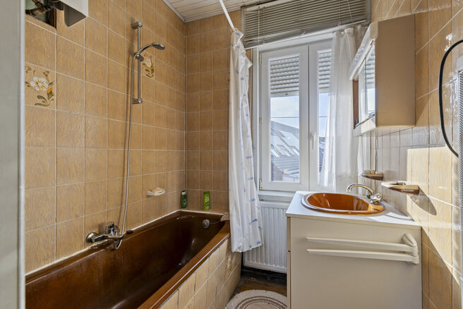 Deze goed gelegen eengezinswoning met ruime tuin en garage/werkplaats ligt op een perceel van 736 m² en bestaat uit twee delen.

Het hoofdgebouw is een volledige gezinswoning met 3 slaapkamers en 1 badkamer. Achteraan bevindt zich een aparte wooneenheid 