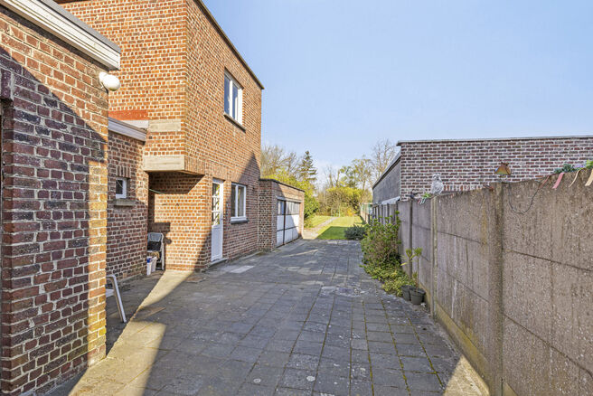 Deze goed gelegen eengezinswoning met ruime tuin en garage/werkplaats ligt op een perceel van 736 m² en bestaat uit twee delen.

Het hoofdgebouw is een volledige gezinswoning met 3 slaapkamers en 1 badkamer. Achteraan bevindt zich een aparte wooneenheid 