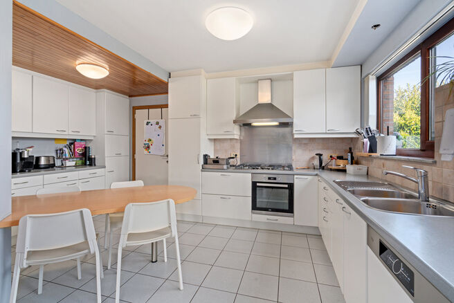 Deze ruime villa met maar liefst 5 slaapkamers en 3 badkamers is gelegen in een residenti&euml;le woonwijk, op een perceel van 15a85ca.

Bij het betreden van de woning komt men in de inkomhal met apart gastentoilet. In 2002 werd de woning uitgebreid met een a