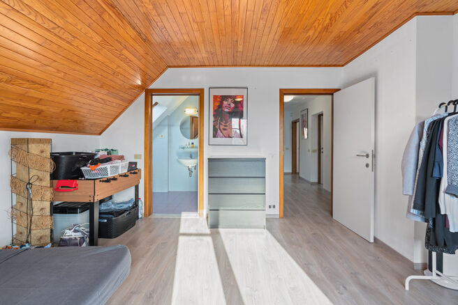 Deze ruime villa met maar liefst 5 slaapkamers en 3 badkamers is gelegen in een residenti&euml;le woonwijk, op een perceel van 15a85ca.

Bij het betreden van de woning komt men in de inkomhal met apart gastentoilet. In 2002 werd de woning uitgebreid met een a