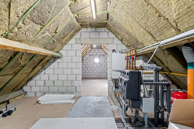 Deze ruime villa met maar liefst 5 slaapkamers en 3 badkamers is gelegen in een residenti&euml;le woonwijk, op een perceel van 15a85ca.

Bij het betreden van de woning komt men in de inkomhal met apart gastentoilet. In 2002 werd de woning uitgebreid met een a