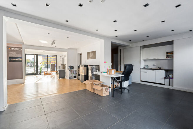 This ground-floor commercial property, located along a busy road with high passing traffic, combines a retail space, warehouse, garage and outdoor areas.

With a total surface area of approximately 148 m&sup2;, a prominent shopfront and a garden, the property