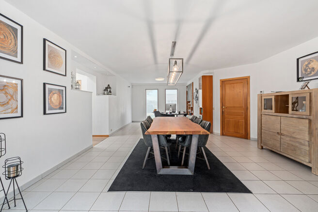 Cette spacieuse villa comprenant pas moins de 5 chambres et 3 salles de bains est situ&eacute;e dans un quartier r&eacute;sidentiel, sur un terrain de 15a85ca.

En entrant dans la maison, vous acc&eacute;dez au hall d&rsquo;entr&eacute;e avec un WC invit&eacute;s s&eacute;par&eacute;. En 2002, la pro