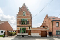 Deze karaktervolle burgerwoning in Vlaamse neotraditionele stijl, met haar statige trapgevel en authentieke elementen, ligt op een royaal perceel van 860 m² in het landelijke Beigem (Grimbergen).

Op het gelijkvloers bevindt zich de inkomhal die toegang 