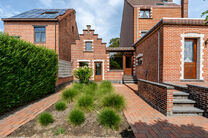 Deze karaktervolle burgerwoning in Vlaamse neotraditionele stijl, met haar statige trapgevel en authentieke elementen, ligt op een royaal perceel van 860 m² in het landelijke Beigem (Grimbergen).

Op het gelijkvloers bevindt zich de inkomhal die toegang 