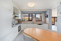 Deze ruime villa met maar liefst 5 slaapkamers en 3 badkamers is gelegen in een residenti&euml;le woonwijk, op een perceel van 15a85ca.

Bij het betreden van de woning komt men in de inkomhal met apart gastentoilet. In 2002 werd de woning uitgebreid met een a