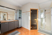 Deze ruime villa met maar liefst 5 slaapkamers en 3 badkamers is gelegen in een residenti&euml;le woonwijk, op een perceel van 15a85ca.

Bij het betreden van de woning komt men in de inkomhal met apart gastentoilet. In 2002 werd de woning uitgebreid met een a