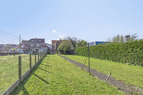 Cette maison unifamiliale idéalement située, avec un grand jardin et un garage/atelier, se trouve sur un terrain de 736 m² et se compose de deux parties.

Le bâtiment principal est une maison familiale complète avec 3 chambres et 1 salle de bain. À 